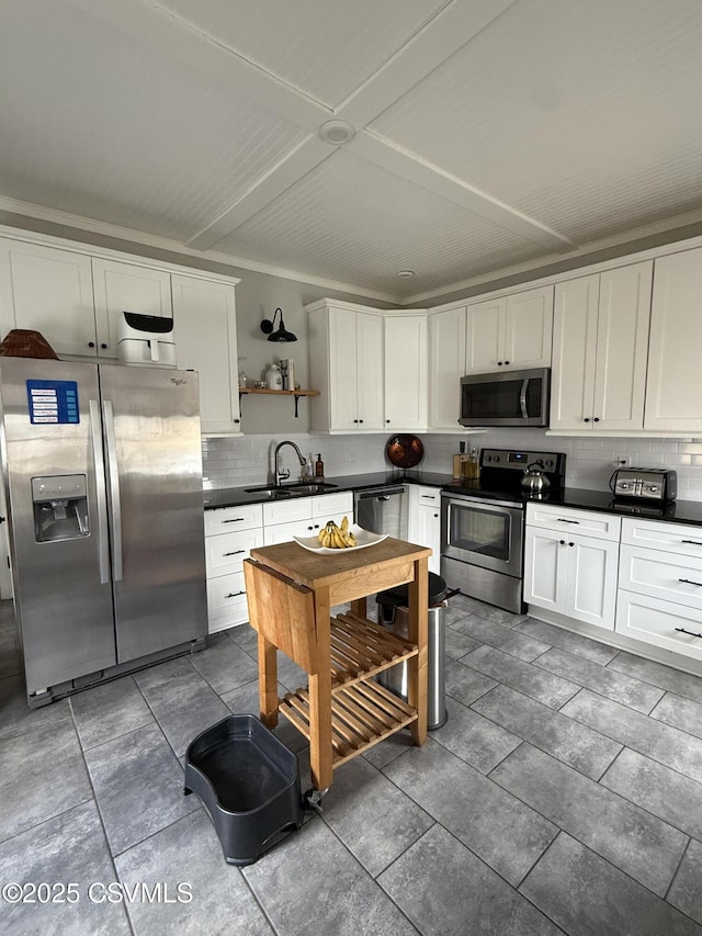 kitchen with open shelves, dark countertops, backsplash, appliances with stainless steel finishes, and a sink