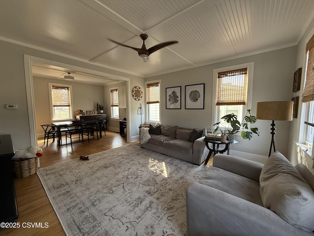 living area with a healthy amount of sunlight, crown molding, and wood finished floors