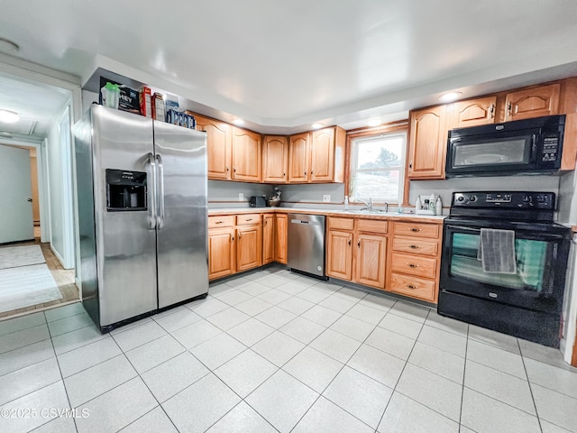 kitchen featuring light countertops, black appliances, and light tile patterned floors