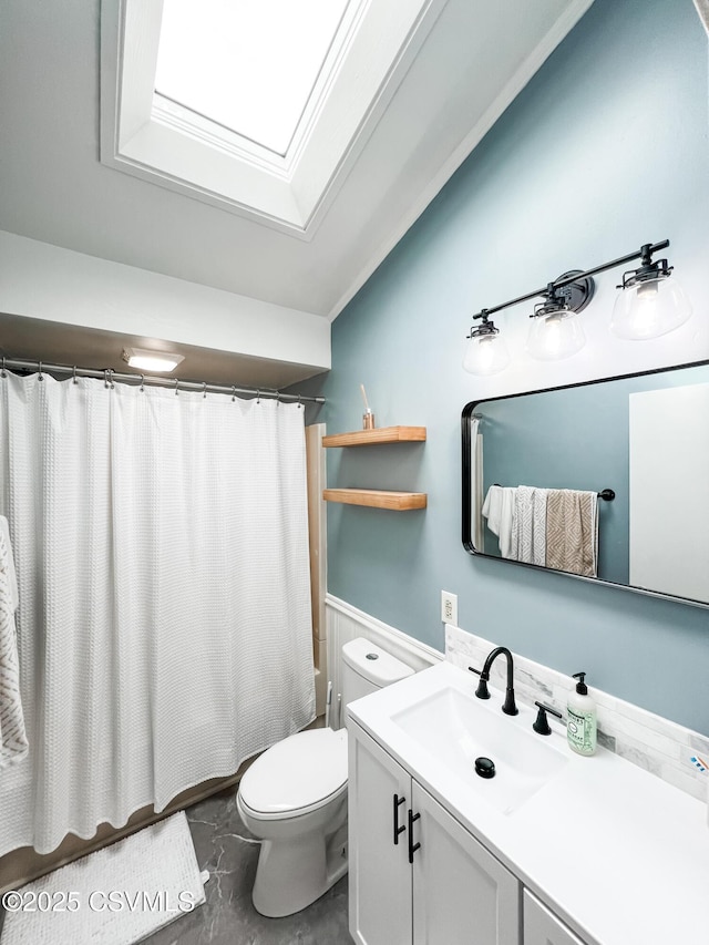 bathroom with vaulted ceiling with skylight, curtained shower, vanity, and toilet