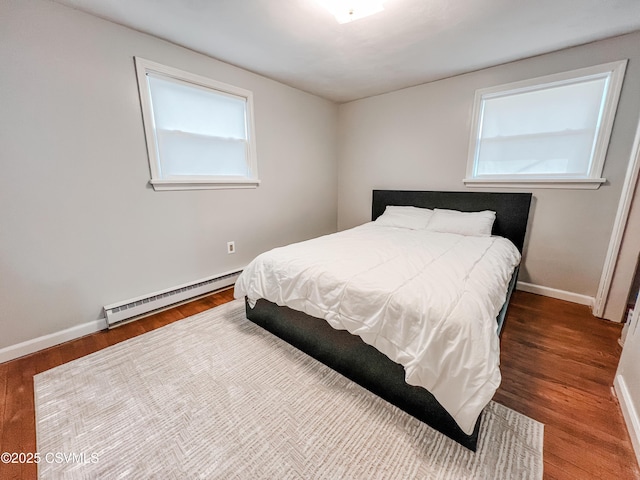 bedroom featuring a baseboard radiator, wood finished floors, and baseboards