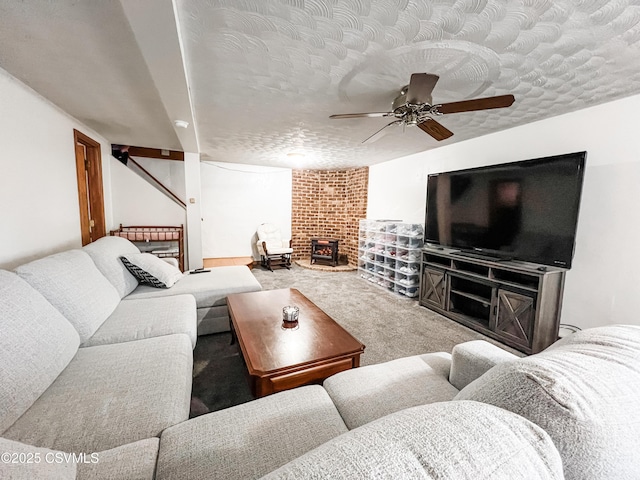 living area featuring carpet, ceiling fan, and a textured ceiling