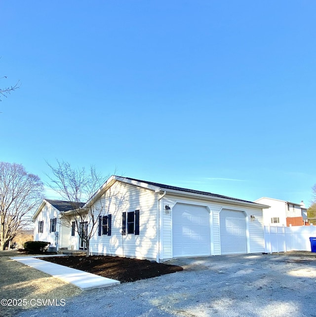 view of home's exterior featuring a garage and fence