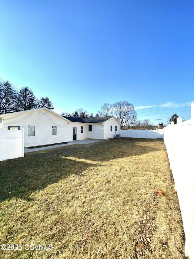 back of house featuring a lawn, a patio area, and a fenced backyard