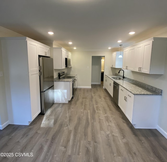 kitchen with stainless steel appliances, white cabinetry, and ornamental molding