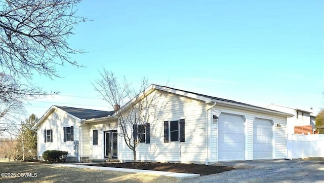 single story home featuring a garage, a chimney, and fence