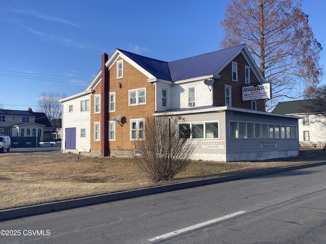 view of front of home with a sunroom and metal roof