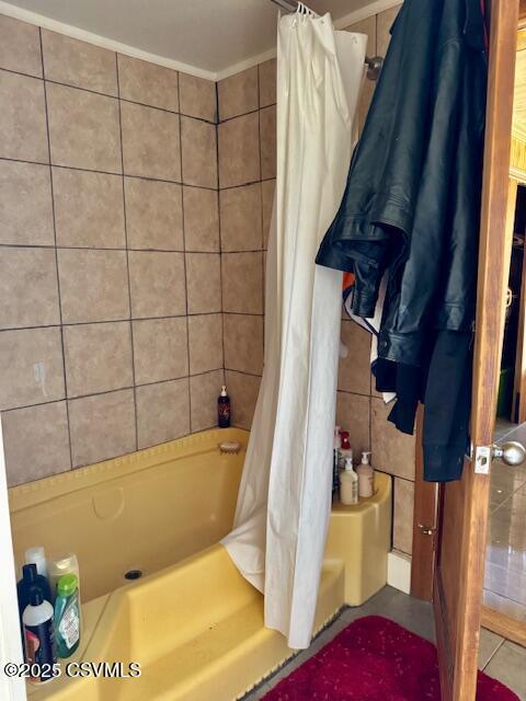 bathroom featuring ornamental molding, tile walls, and shower / tub combo with curtain