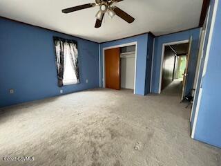 unfurnished bedroom featuring a ceiling fan and a closet