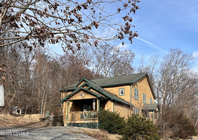 rustic home featuring driveway and a porch