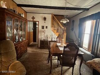 dining area featuring a notable chandelier, stairs, and beamed ceiling