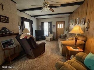 living room featuring ceiling fan, carpet floors, wood walls, and beam ceiling