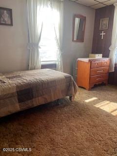 bedroom with light carpet and a paneled ceiling