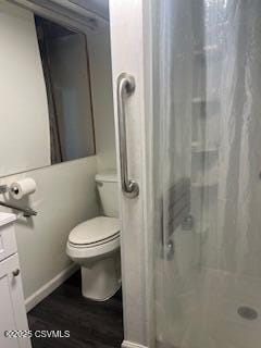 bathroom featuring toilet, vanity, a shower with shower curtain, and wood finished floors