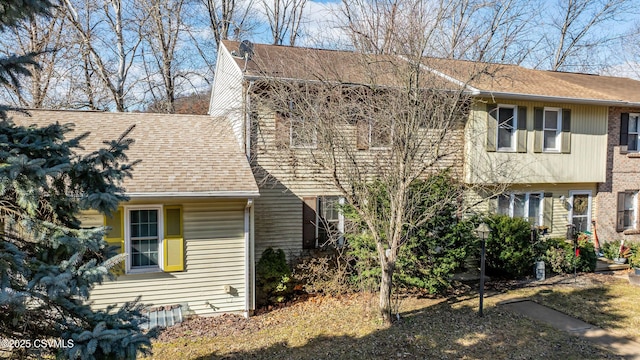 view of front of house with a shingled roof and brick siding