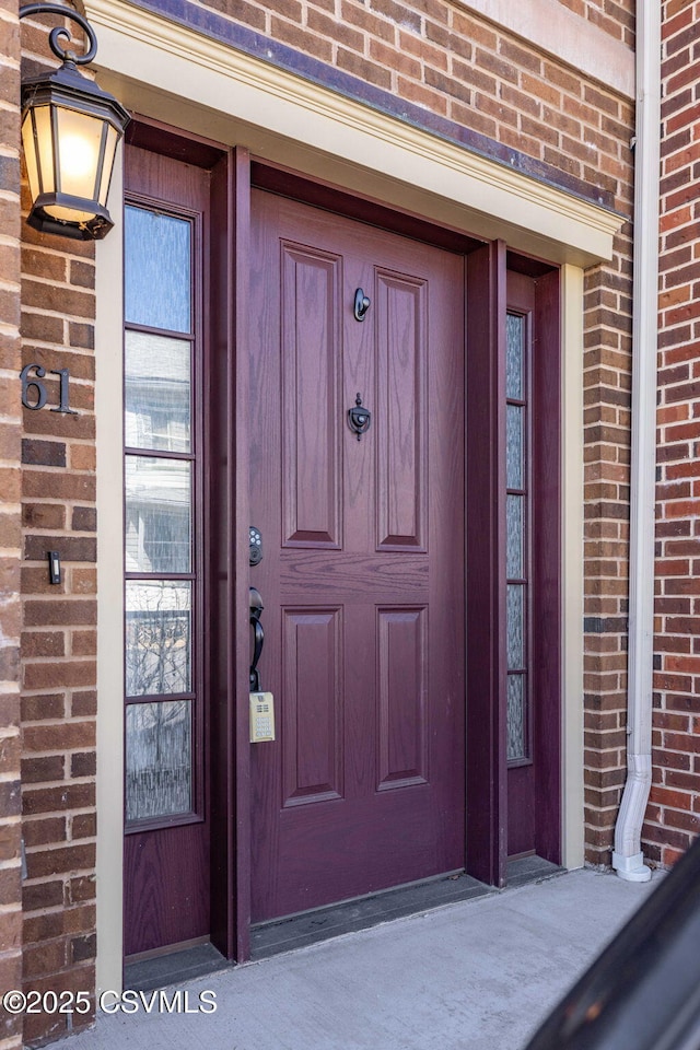 property entrance featuring brick siding