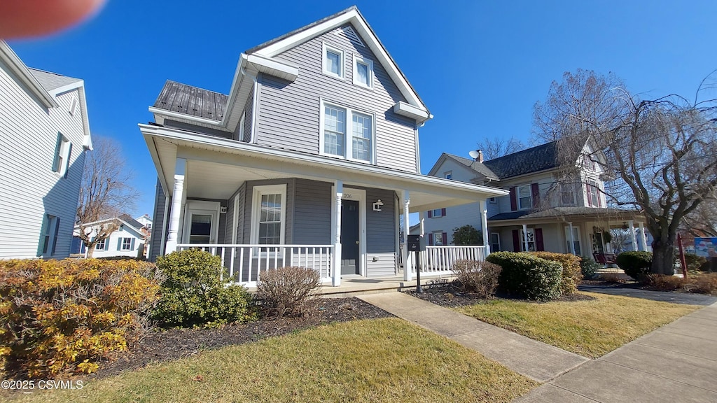 view of front of home with a porch and a front yard