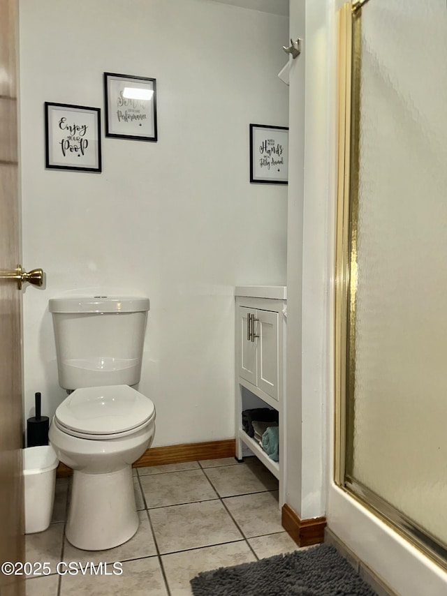 bathroom with tile patterned flooring, baseboards, toilet, and an enclosed shower