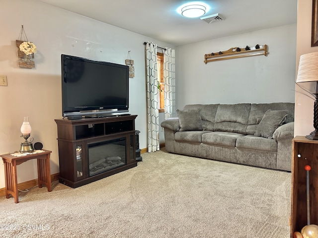 living area with carpet, a glass covered fireplace, visible vents, and baseboards