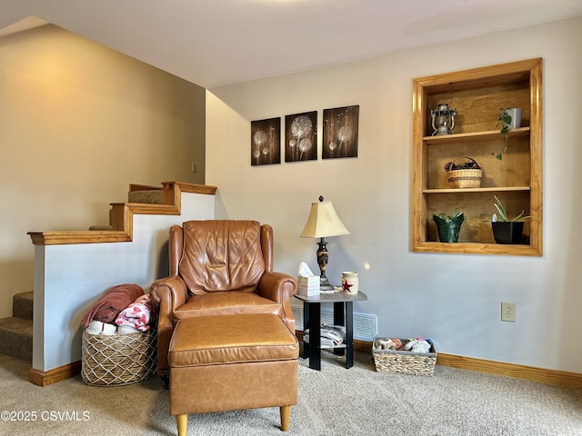 sitting room with carpet flooring, baseboards, and stairs