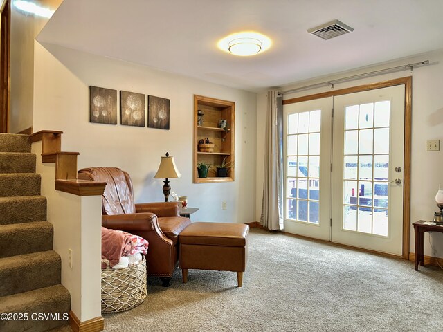 living area with carpet floors, stairway, visible vents, and a wealth of natural light