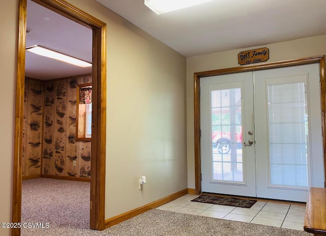 doorway to outside with light carpet, light tile patterned flooring, baseboards, and french doors