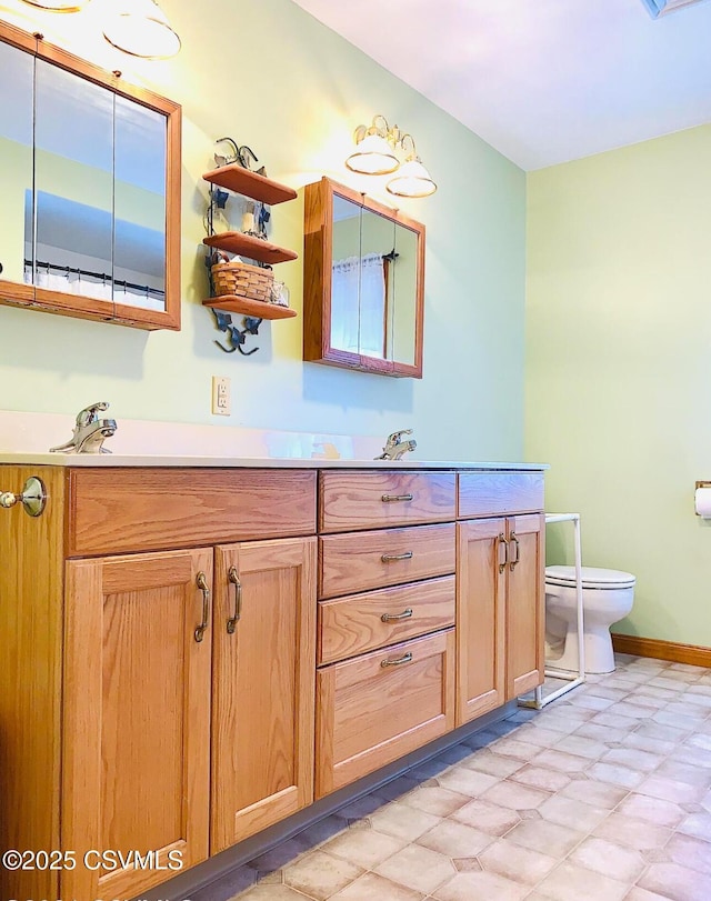 bathroom featuring toilet, tile patterned floors, baseboards, and vanity