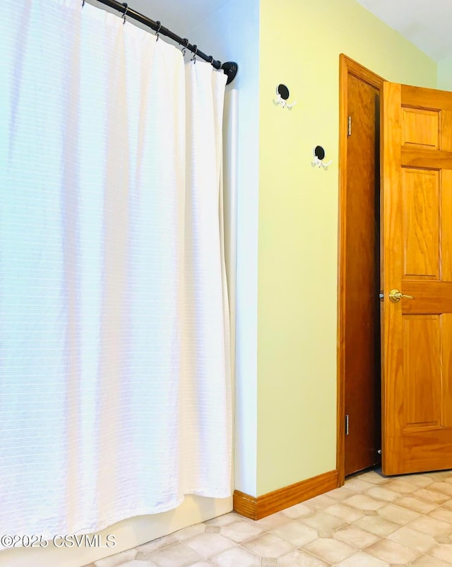 bathroom featuring a shower with curtain and baseboards