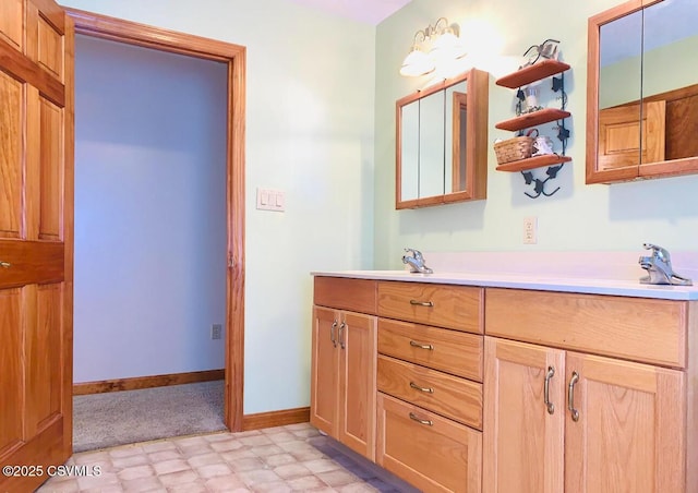 full bath featuring double vanity, baseboards, and tile patterned floors