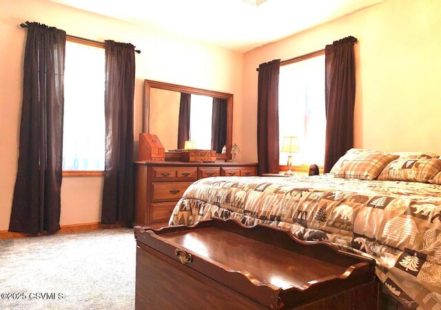 bedroom featuring baseboards and light colored carpet