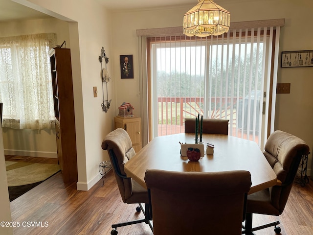 dining room featuring a notable chandelier, baseboards, and wood finished floors