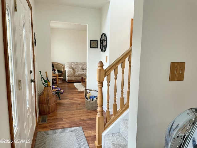 foyer with stairway, wood finished floors, and visible vents