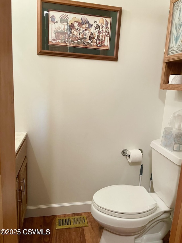 bathroom featuring baseboards, visible vents, vanity, and toilet