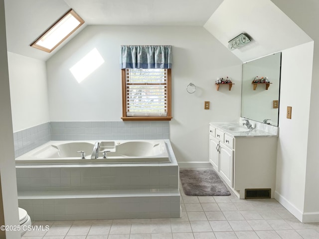 bathroom featuring visible vents, lofted ceiling with skylight, tile patterned floors, a garden tub, and vanity