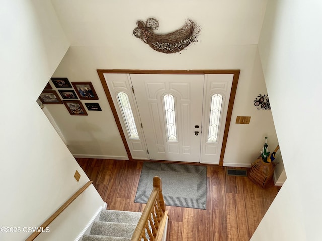 entrance foyer with stairs, baseboards, and wood finished floors