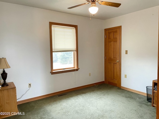 carpeted spare room featuring visible vents, a ceiling fan, and baseboards