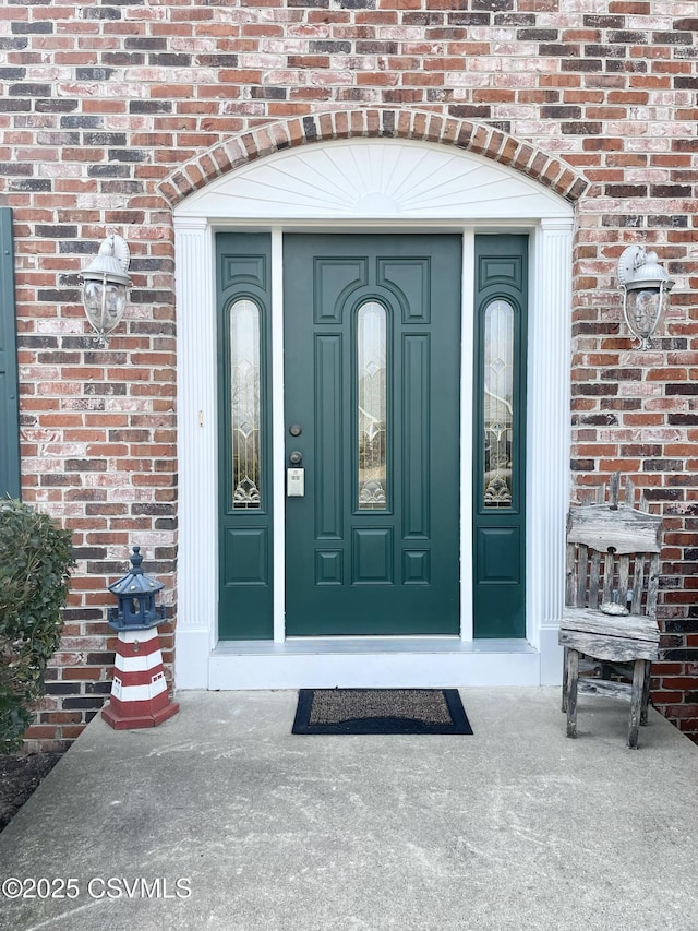 view of exterior entry with brick siding