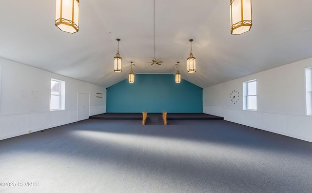 bonus room featuring a healthy amount of sunlight, wainscoting, and vaulted ceiling