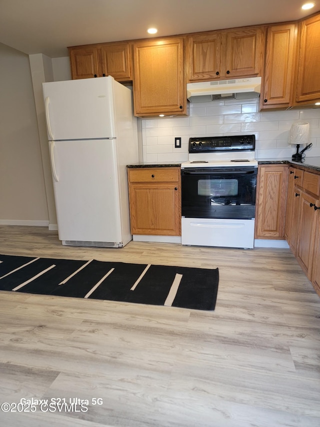 kitchen with under cabinet range hood, range with electric stovetop, light wood-type flooring, and freestanding refrigerator