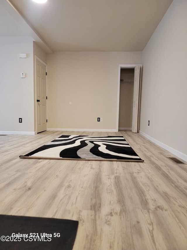 unfurnished room featuring visible vents, baseboards, and light wood-style floors