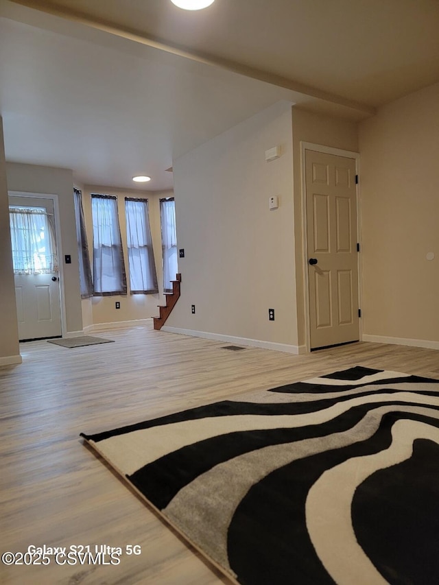 entryway featuring stairs, visible vents, baseboards, and light wood finished floors