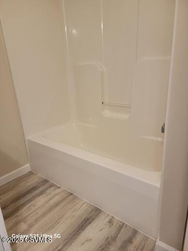 full bathroom with baseboards, bathtub / shower combination, and wood finished floors