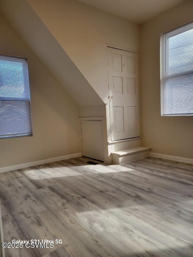 bonus room with lofted ceiling, wood finished floors, and baseboards