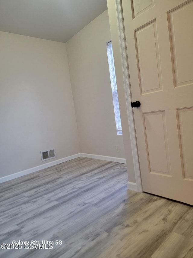 unfurnished room with visible vents, baseboards, and light wood-style floors