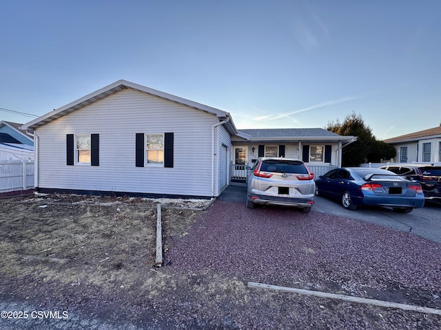 ranch-style house featuring fence