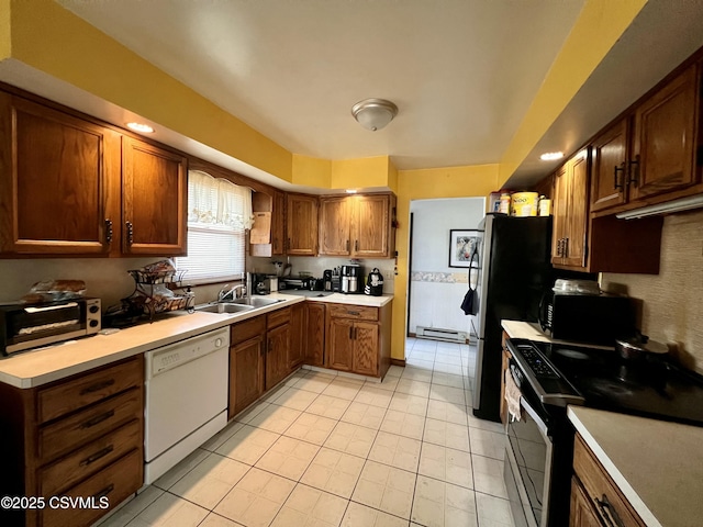 kitchen with light countertops, a toaster, a sink, and black appliances