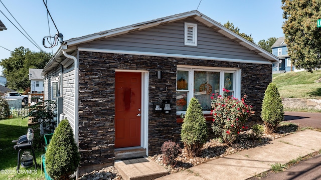 bungalow-style house featuring stone siding