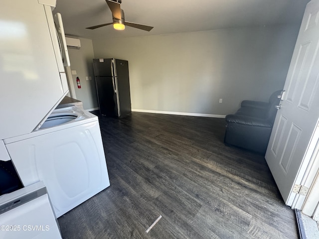 interior space featuring dark wood-style flooring, stacked washer / drying machine, freestanding refrigerator, a wall mounted air conditioner, and baseboards