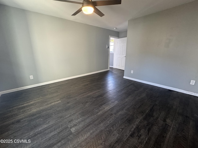 unfurnished room with ceiling fan, dark wood finished floors, and baseboards