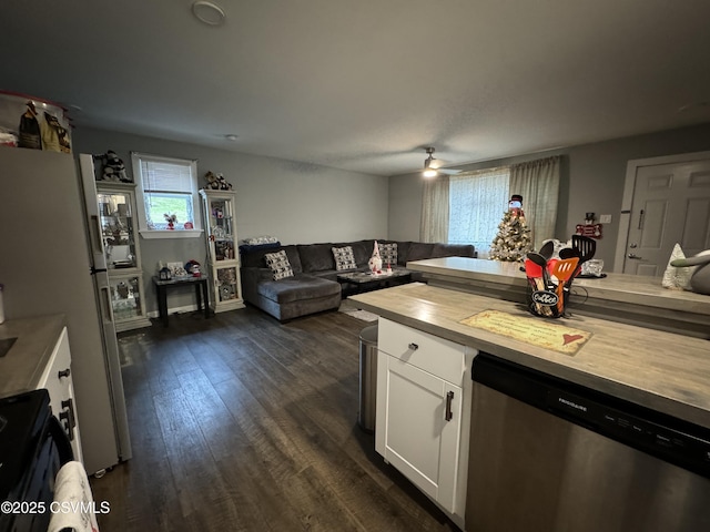 kitchen with stainless steel dishwasher, dark wood-type flooring, open floor plan, white cabinets, and wood counters